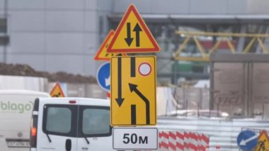 Yol çalışmaları trafik işaretlerini uyardı. Şehir caddesinde inşaat çalışması ve yavaş hareket eden arabalar.