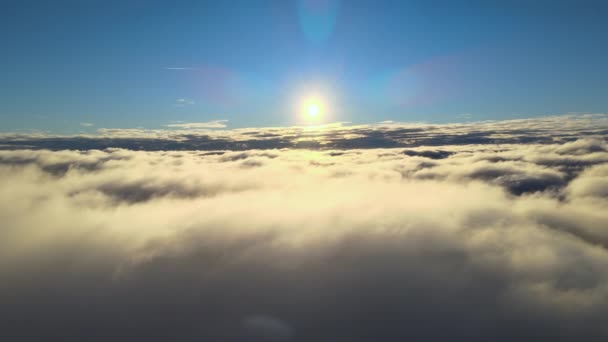 Вид зверху з висоти на висоту густих пухнастих кумульських хмар, що летять ввечері. Дивовижний захід сонця з точки зору вікна літака — стокове відео