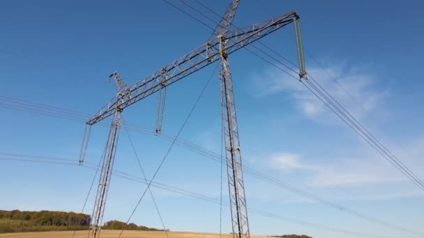 Stalowy słup z wysokonapięciowymi liniami elektroenergetycznymi dostarczającymi energię elektryczną przez przewody kablowe na długich dystansach — Wideo stockowe