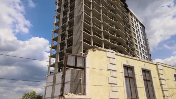 Detalhe arquitetônico de quadro alto de edifício de concreto monolítico em construção e casa demolida velha em frente. Desenvolvimento imobiliário — Vídeo de Stock