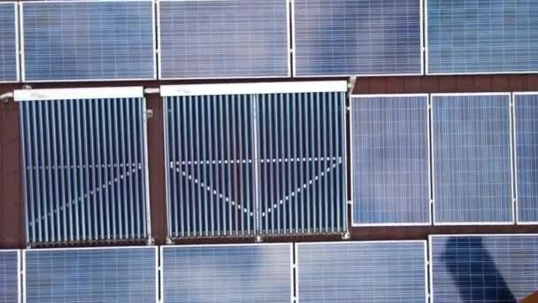 用一排蓝色光电面板和真空空气太阳能集热器建造屋顶，用于水加热和产生清洁的生态电。零排放可再生能源和热能 — 图库视频影像