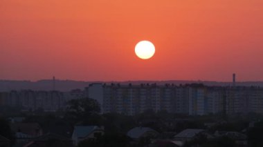 Güneş batarken akşam manzarası Uzak şehrin yüksek binalarının üzerinde gün batımında
