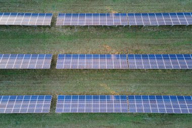 Temiz ekolojik elektrik enerjisi üretmek için sıra sıra güneş fotovoltaik panelleri olan sürdürülebilir büyük elektrik santralinin havadan görünüşü. Sıfır emisyon kavramı ile yenilenebilir elektrik