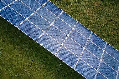Temiz elektrik enerjisi üretmek için sıra sıra güneş fotovoltaik panelleri olan sürdürülebilir büyük elektrik santralinin havadan görünüşü. Sıfır emisyonlu yenilenebilir elektrik kavramı