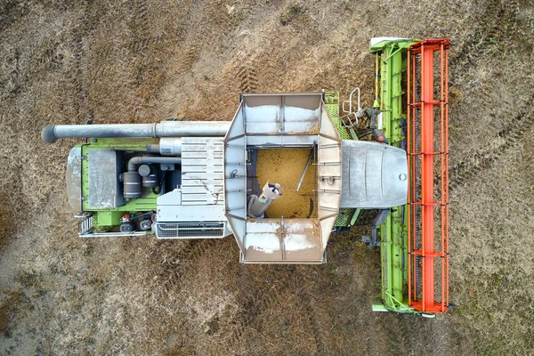 Vista aérea de combinar colheitadeira trabalhando durante a época de colheita em grande campo de trigo maduro. Conceito de agricultura — Fotografia de Stock