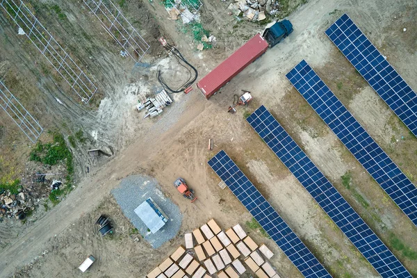 Letecký pohled na elektrárnu ve výstavbě s nákladním vozidlem dodávajícím montážní díly pro solární panely na kovovém rámu pro výrobu elektrické energie. Vývoj elektřiny z obnovitelných zdrojů — Stock fotografie