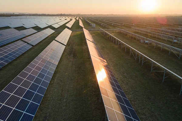 Akşamları temiz elektrik enerjisi üretmek için sıra sıra güneş fotovoltaik panelleri olan sürdürülebilir büyük elektrik santralinin havadan görünüşü. Sıfır emisyonlu yenilenebilir elektrik kavramı