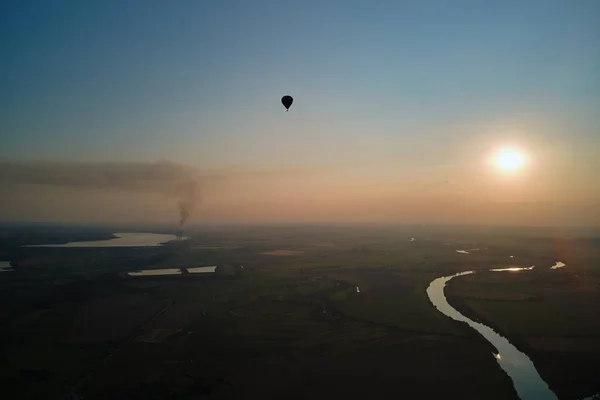 Luchtfoto van kleine hete lucht ballon vliegen over het platteland bij zonsondergang — Stockfoto