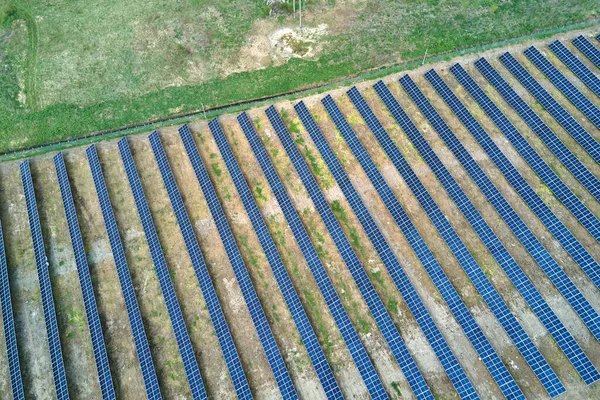 Letecký pohled na solární elektrárnu na zeleném poli. Elektrická farma s panely pro výrobu čisté ekologické energie — Stock fotografie