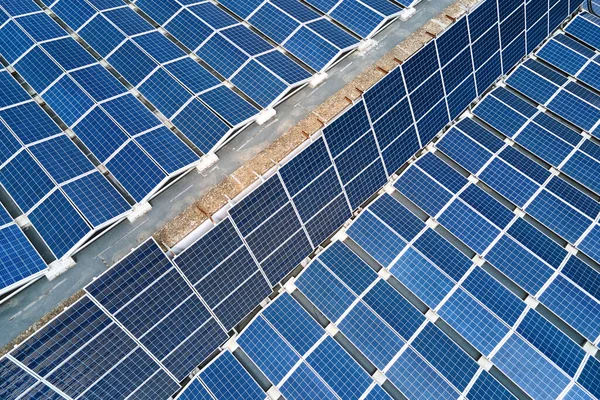 Vista aérea de la planta de energía solar con paneles fotovoltaicos azules montados en el techo del edificio industrial para producir electricidad ecológica verde. Producción del concepto de energía sostenible — Foto de Stock