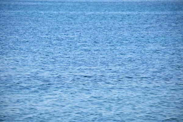 Primer plano de la superficie del paisaje marino de agua de mar azul con pequeñas olas onduladas — Foto de Stock