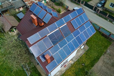 Şehrin kırsal kesimlerinde temiz ekolojik elektrik enerjisi üretmek için güneş fotovoltaik panellerle kaplı özel bir çatı. Özerk ev kavramı