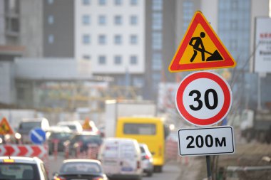 Yol çalışmaları trafik işaretlerini uyardı. Şehir caddesinde inşaat çalışması ve yavaş hareket eden arabalar.