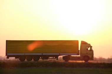 Kargo karavanı olan yarı kamyon akşam vakti otobanda mal taşır. Teslimat ulaşım ve lojistik kavramı