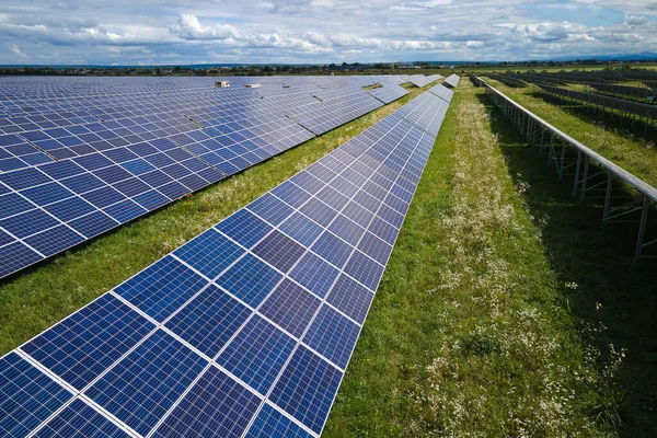 Temiz elektrik enerjisi üretmek için sıra sıra güneş fotovoltaik panelleri olan sürdürülebilir büyük elektrik santralinin havadan görünüşü. Sıfır emisyonlu yenilenebilir elektrik kavramı