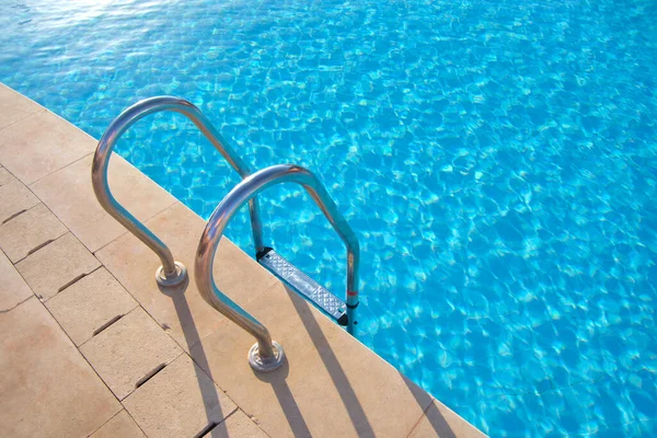 Close up of swimming pool stainless steel handrail descending into tortoise clear pool water. Accessibility of recreational activities concept — Stock Photo, Image