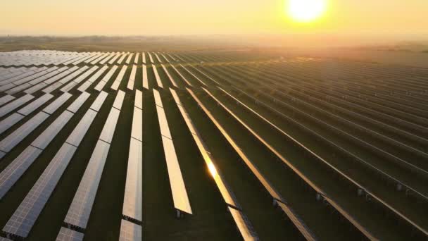 Αεροφωτογραφία του μεγάλου βιώσιμου σταθμού ηλεκτρικής ενέργειας με πολλές σειρές ηλιακών φωτοβολταϊκών πάνελ για την παραγωγή καθαρής ηλεκτρικής ενέργειας κατά το ηλιοβασίλεμα. Ανανεώσιμη ηλεκτρική ενέργεια με μηδενικές εκπομπές — Αρχείο Βίντεο