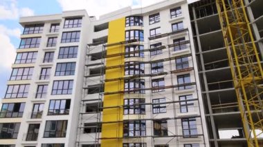 Vinç kaldırma kulesi ve inşaat halindeki monolitik çerçeveli yüksek konutlu bina. Gayrimenkul geliştirme