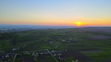 Yeşil ekili tarlaların, büyüyen ekinlerin ve parlak yaz akşamlarında uzak köy evlerinin hava manzarası.