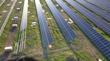 Metal çerçevede temiz elektrik enerjisi üreten birçok sıra güneş paneli bulunan büyük elektrik santralinin havadan görüntüsü. Yenilenebilir elektrik kaynaklarının geliştirilmesi