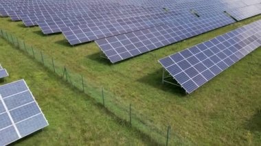 Temiz elektrik enerjisi üretmek için sıra sıra güneş fotovoltaik panelleri olan sürdürülebilir büyük elektrik santralinin havadan görünüşü. Sıfır emisyonlu yenilenebilir elektrik kavramı