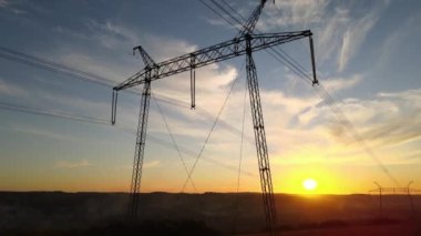 Gün batımında elektrik hatları olan yüksek voltaj kulesi. Elektrik aktarımı
