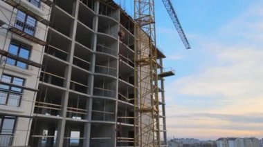 Vinç kaldırma kulesi ve inşaat halindeki monolitik çerçeveli yüksek konutlu bina. Gayrimenkul geliştirme