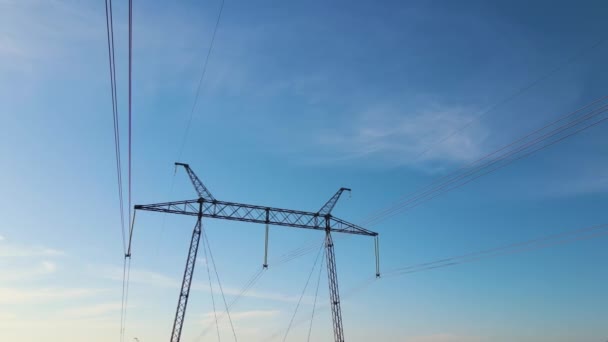 Wieża wysokiego napięcia z liniami elektroenergetycznymi transfekującymi energię elektryczną przez przewody kablowe — Wideo stockowe