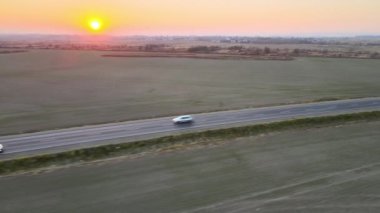 Gün batımında otobanda yük taşıyan küçük bir kargo aracının hava görüntüsü. Teslimat ulaşım ve lojistik kavramı