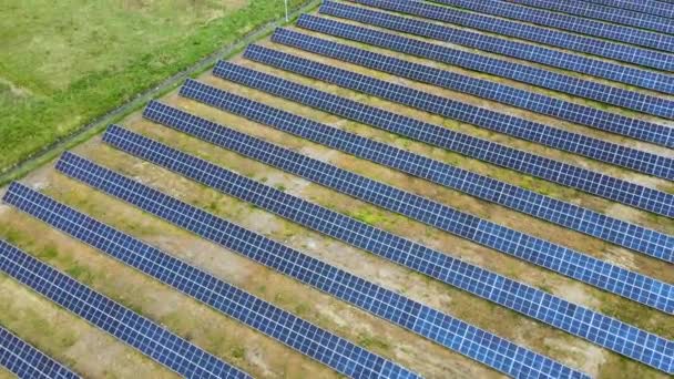 Vista aérea de una gran central eléctrica sostenible con muchas filas de paneles fotovoltaicos solares para producir energía eléctrica ecológica limpia. Electricidad renovable con concepto de cero emisiones — Vídeos de Stock