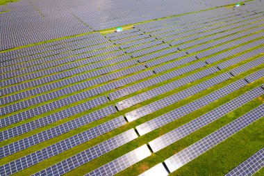 Yeşil alandaki güneş enerjisi santralinin havadan görüntüsü. Temiz ekolojik enerji üretmek için elektrik panelleri