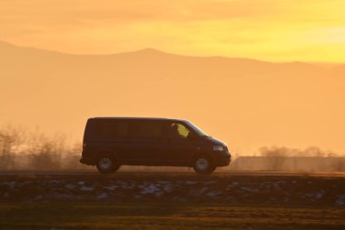 Yolcu kamyonu gün batımında şehirlerarası yolda hızla gidiyor. Akşamları otoyol trafiği