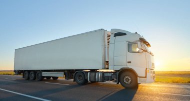 Kargo karavanı olan yarı kamyon akşam vakti otobanda mal taşır. Teslimat ulaşım ve lojistik kavramı