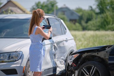 Stresli kadın sürücü, trafik kazası üstüne trafik kazası sonrası cep telefonu kamerasıyla fotoğraf çekiyor. Yol güvenliği ve sigorta kavramı