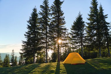 Parlak güneşli bir akşamda dağ kamp alanında turist kampı çadırı. Aktif turizm ve yürüyüş konsepti