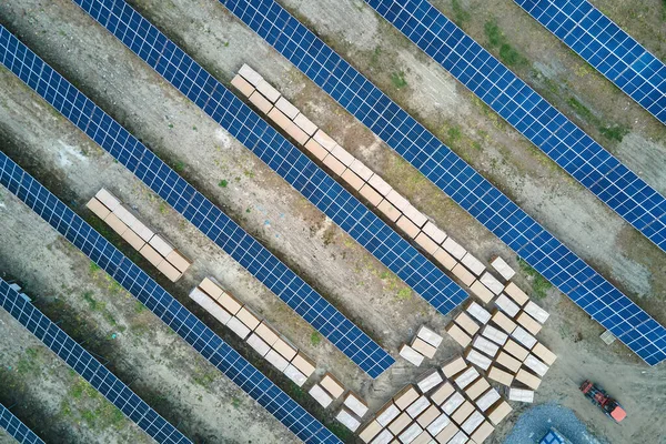 Vista aérea de la gran planta de energía eléctrica en construcción con muchas filas de paneles solares en el marco de metal para producir energía eléctrica limpia. Desarrollo de fuentes de electricidad renovables — Foto de Stock