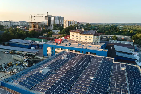 Sanayi binasının çatısına yeşil ekolojik elektrik üretmek için monte edilmiş mavi fotovoltaik panelli güneş enerjisi santralinin hava görüntüsü. Sürdürülebilir enerji konsepti üretimi — Stok fotoğraf