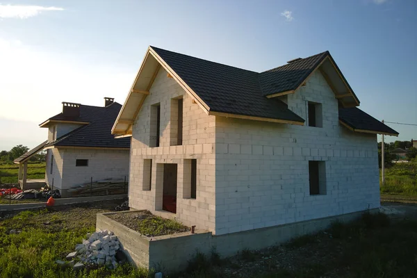 Vista aérea de casa inacabada con paredes de hormigón ligero aireado y marco de techo de madera cubierto con azulejos metálicos en construcción — Foto de Stock