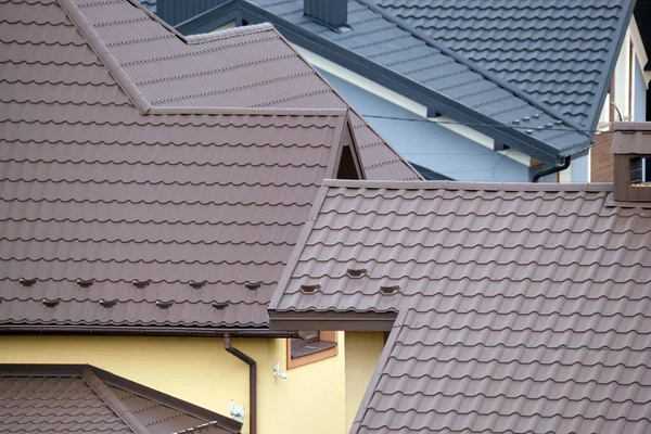 Zbliżenie dachu domu pokrytego metalowymi gontami. Pokrycie dachowe budynku — Zdjęcie stockowe