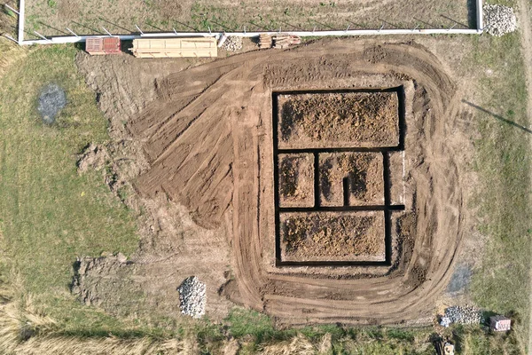 Ausgegrabener Graben für Bauarbeiten an neuem Hausbetonfundament auf Baustelle — Stockfoto