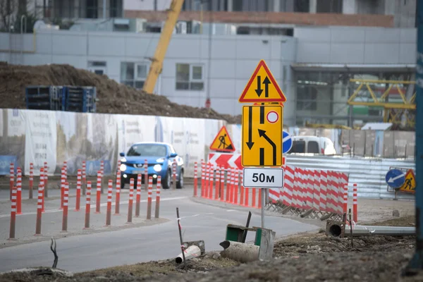 Trabajos de carretera que advierten señales de tráfico de obras de construcción en la calle de la ciudad y coches en movimiento lento — Foto de Stock