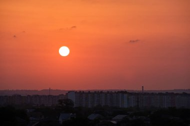 Güneş batarken akşam manzarası Uzak şehrin yüksek binalarının üzerinde gün batımında
