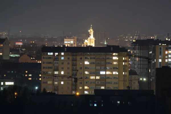 Architektoniczne detale nowoczesnych wysokich budynków mieszkalnych z wieloma oświetlonymi oknami i balkonami w nocy — Zdjęcie stockowe