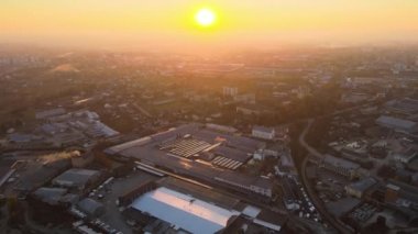 Sanayi binasının çatısına yeşil ekolojik elektrik üretmek için monte edilmiş mavi fotovoltaik panelli güneş enerjisi santralinin hava görüntüsü. Sürdürülebilir enerji konsepti üretimi