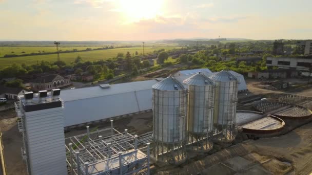 Vista aérea de silos industriales ventilados para almacenamiento a largo plazo de granos y semillas oleaginosas. Elevador metálico para secado de trigo en zona agrícola — Vídeos de Stock