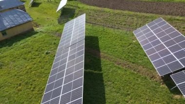 Temiz ekolojik elektrik üretmek için arka bahçeye monte edilen mavi fotovoltaik güneş panellerinin hava görüntüsü. Yenilenebilir enerji konsepti üretimi