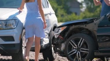 Öfkeli kadın ve ağır hasarlı araçların erkek sürücüleri trafik kazasında kimin suçlu olduğunu savunuyorlar. Yol güvenliği ve sigorta kavramı
