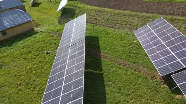 クリーンな生態系電気を生成するための裏庭の地面に取り付けられた青い太陽光発電パネルの空中ビュー。再生可能エネルギーの概念の生産 — ストック動画