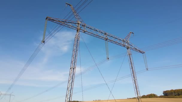 Wieża wysokiego napięcia z liniami elektroenergetycznymi transfekującymi energię elektryczną przez przewody kablowe — Wideo stockowe