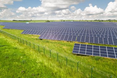 Yeşil alandaki güneş enerjisi santralinin havadan görüntüsü. Temiz ekolojik enerji üretmek için elektrik panelleri